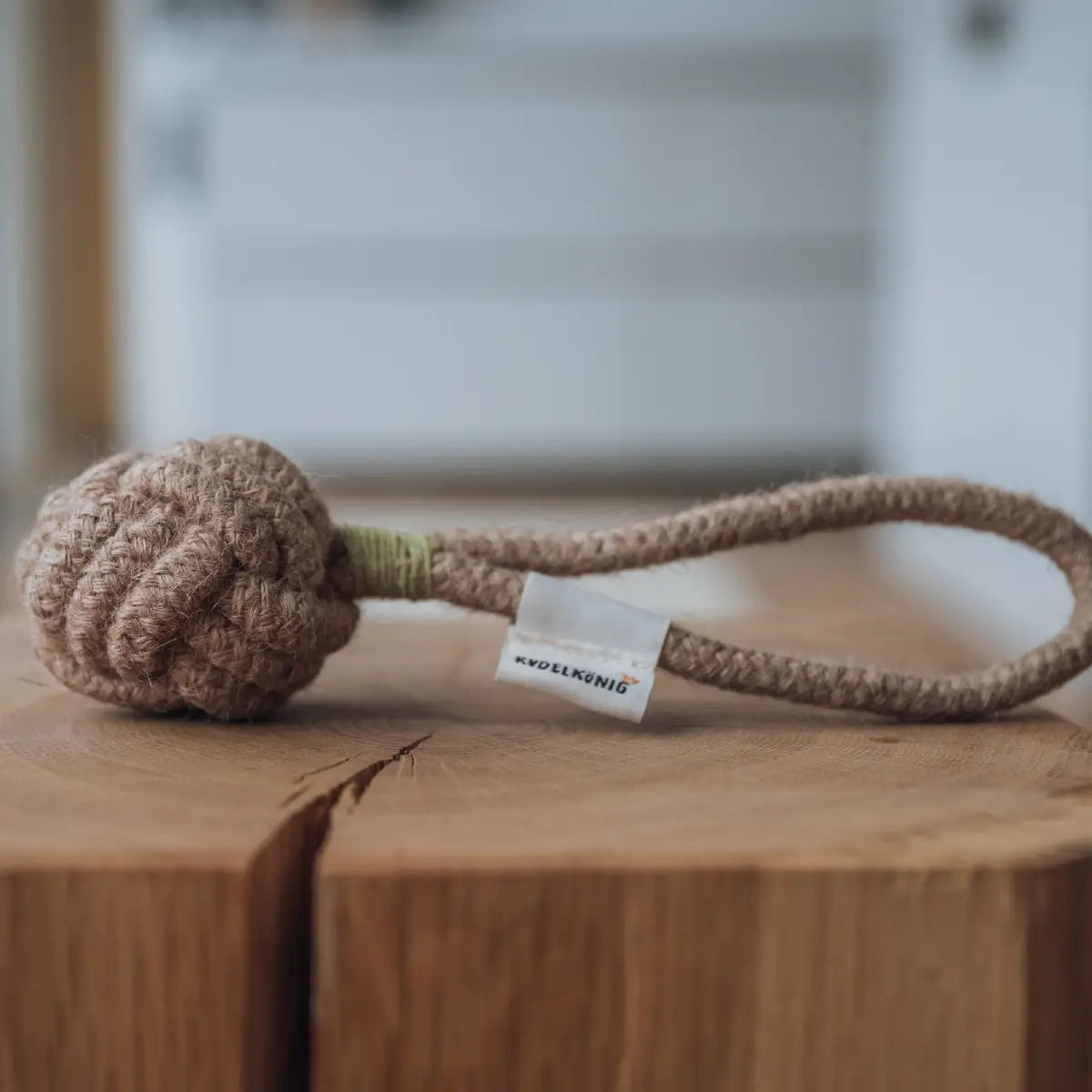 Rudelkönig Seilspielzeug aus 100% Baumwolle liegt auf einem Baumstumpf im Wohnzimmer.