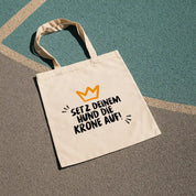 Baumwollbeutel von Rudelkönig mit Slogan Print zum Shoppen und für Ausflüge liegt auf einem Sport Spielfeld.