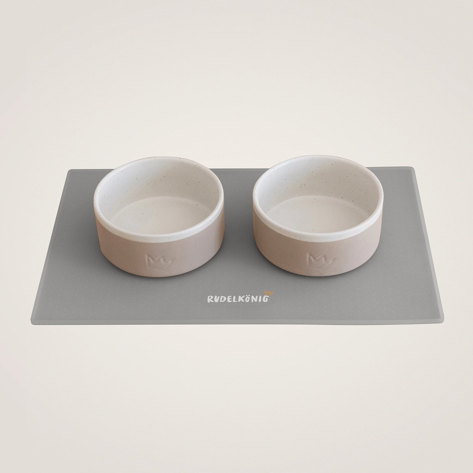 Das Rudelkönig Hundenapf Set aus Keramik bestehend aus zwei Näpfen mit jeweils 900ml Fassungsvermögen und einer rutschfesten Futtermatte in grau.