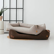 Die beiden Hundebetten Koye von Rudelkönig in taupe und Cord dunkelbraun liegen auf dem Boden übereinander.