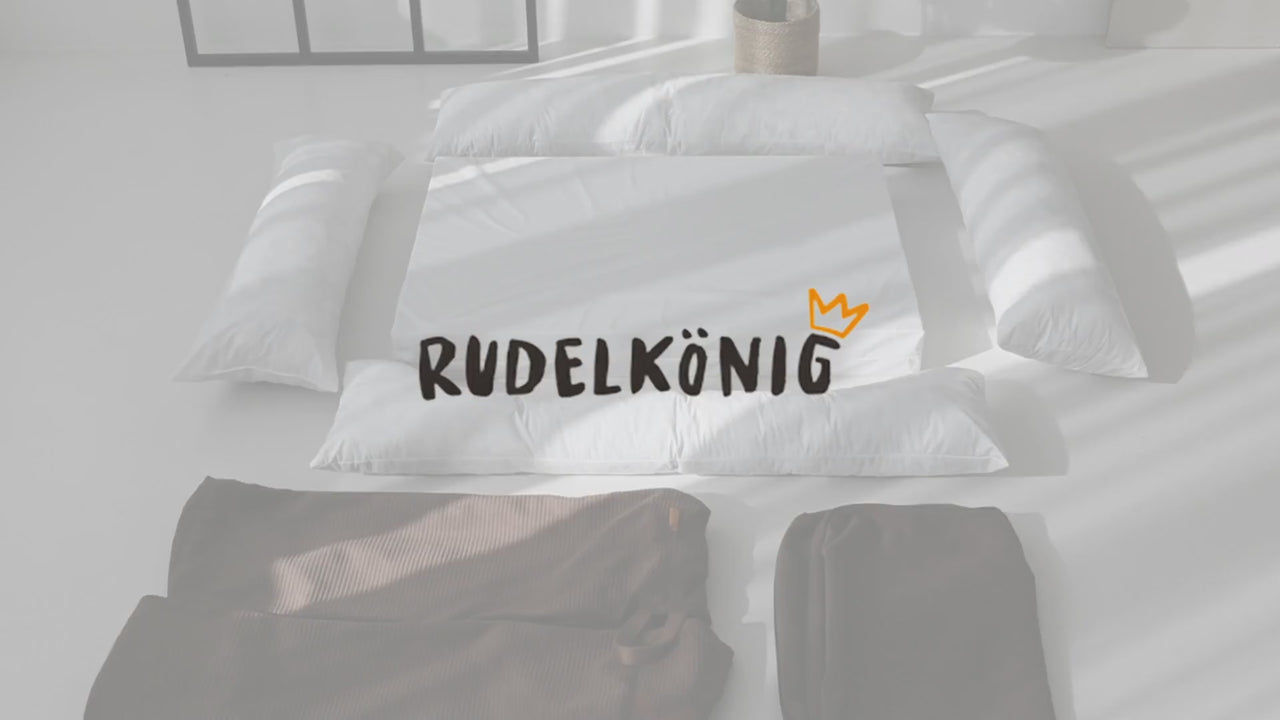 Frau baut das Hundebett Koye von Rudelkönig zusammen und zeigt, in welchen Schritten was erfolgt.